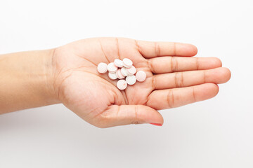 Macro Close up of medicinal or herbal white color pill on a female hand palm. Top view,