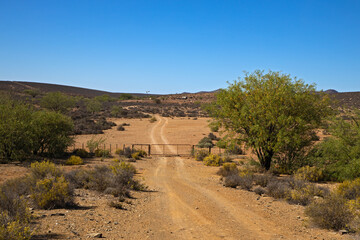 Gated dirt track to remote farm in Karoo