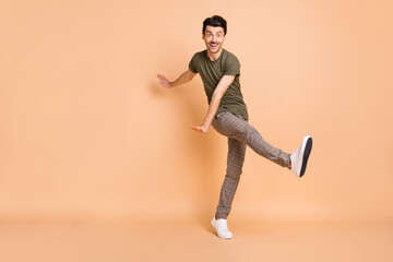 Fototapeta na wymiar Full length body size photo of dancing guy spending free time wearing stylish outfit smiling isolated on pastel beige color background