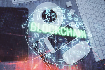 Double exposure of blockchain theme hologram over table with phone. Top view. Crypto technology concept.