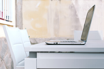 Open laptop on terrace table ready for teleworking