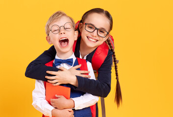 Happy schoolgirl giving piggyback ride to boy