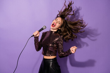 Portrait of attractive popular cheerful girl having fun singing single rock hit isolated over bright violet color background