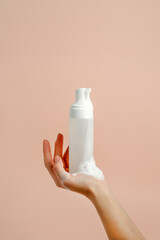 Woman hand press Pure white plastic pump bottle and other hand take cleaner foam, dispenser with antiseptic or antimicrobial soap. Healthcare, daily routine during pandemic covid-19 concept - 426016322