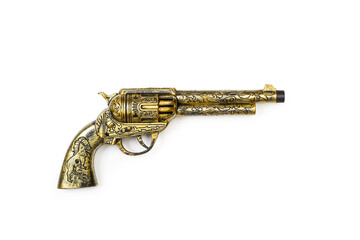 Revólver de juguete dorado Western sobre un fondo blanco liso y aislado. Vista superior. Copy space