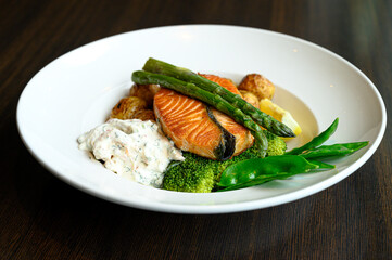 Salmon with baked potatoes, asparagus and sauce