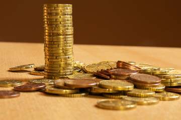 Pile of coins on a table with a lot of different coins around it.Save money concept banner .