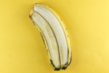 two bananas that merge into one. unique banana. photo with yellow background