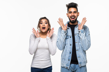 Astonishment and surprise concept. Young indian couple or family in casual clothing screaming, looking at camera in shock and full disbelief isolated on white background