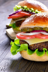 Cheeseburger on a wooden background. Hamburger with cheese. Burger isolated. Tasty Dinner.Copy space. Vertical orientation