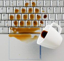 Coffee spilled on computer notebook keyboard close up