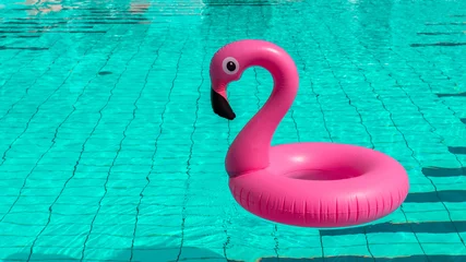 Gardinen Beach flamingo. Pink inflatable flamingo in pool water for summer beach background. Trendy summer concept. © Maksym