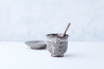 Traditional, handcrafted ceramic on bright wooden background. Soft focus. Copy space.