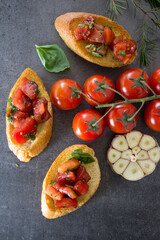 Italian bruschetta with roasted tomatoes, basil and garlic. Top view photo of savory toast. Healthy eating concept. 