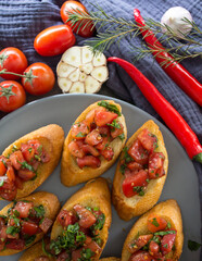 Tasty bruschetta with roasted tomatoes and basil. Close up photo of  toasted bread and fresh vegetables. Authentic Italian food. 