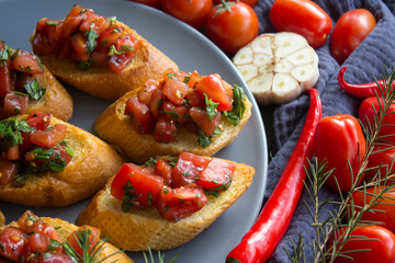 Tasty bruschetta with roasted tomatoes and basil. Close up photo of  toasted bread and fresh vegetables. Authentic Italian food. 