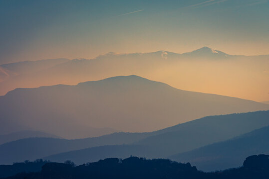 Hazy sunrise over the silhouettes of the mountains 