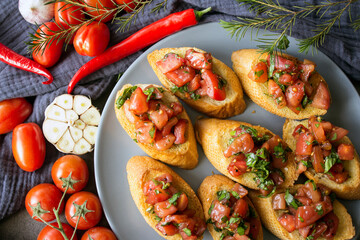 Tasty bruschetta with roasted tomatoes and basil. Close up photo of  toasted bread and fresh vegetables. Authentic Italian food. 