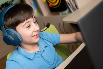 Smiling boy using laptop at home. On-line or e-learning education on quarantine. Soft focus