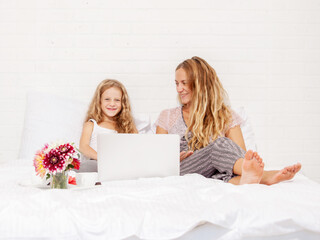 Obraz na płótnie Canvas Family with laptop in bed