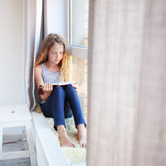 Girl reading book at home