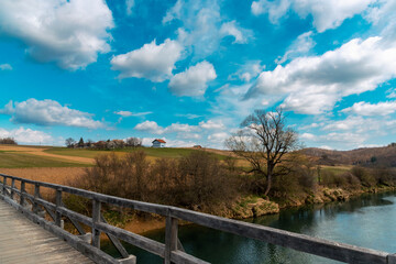 Fototapeta na wymiar Rural landscape, wooden bridge and blue sky with clouds