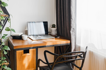 Modern workplace at home with laptop on wooden table