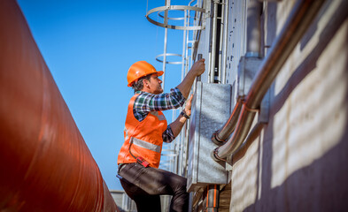 Portrait industry worker under checking the industry cooling tower air conditioner is water cooling tower air chiller HVAC of large industrial building to control air system.