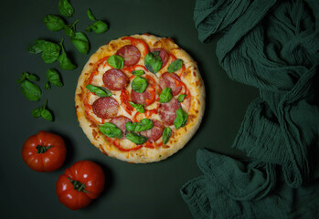 Pizza in flight on a dark background.The concept of an advertising flyer and poster for restaurants or pizzerias, a template with a hot delicious pizza close-up with vegetables and herbs. menu