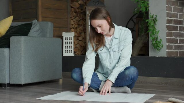 Young woman looking at the blueprints of their new house