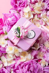 box with gift  around roses  and  jasmine background. romantic and beauty concept. top view