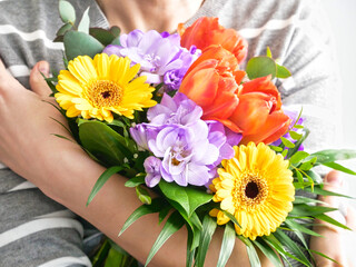 woman's hands holding a bouquet of colorful flowers. mothers day or womens day background. Gift and present concept.