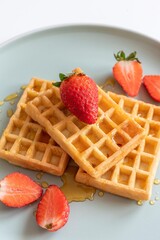 waffles with honey and sliced strawberry isolated on plate. 
