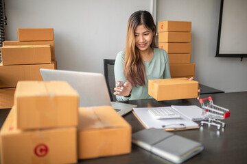 Portrait of Starting small businesses SME owners female entrepreneurs Write the address on receipt box and check online orders, prepare to pack the boxes, sell,customers, sme business ideas online.