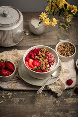 Obraz na płótnie Canvas Petit déjeuner bol de granola yaourt fraises et framboises