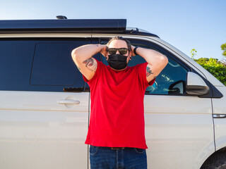 Hombre joven con mascarilla en una furgoneta durante el coronavirus