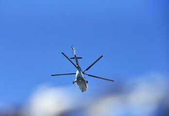 Helicopter flies in the air against a blue sky