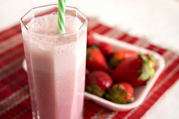strawberry smoothie and tray with strawberries in the background