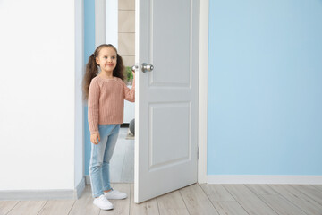 Fototapeta na wymiar Cute little girl standing in doorway