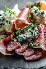 Fototapeta na wymiar Antipasto platter with jamon, prosciutto, salami, blue cheese, Appetizers. meat snacks on a slate board. Food recipe background. Close up.