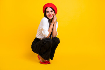 Full size photo of happy nice young woman sit hold hands face wear stilettos isolated on yellow...