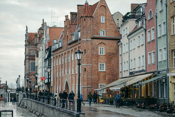 Fototapeta na wymiar A group of people walking down a street next to tall buildings