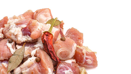 Raw pieces of pork shish kebab in marinade with pepper, onion,bay leaf, ready to cook, barbecue meat, isolated on a white background.