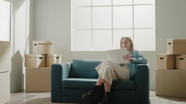 Lady sits on turquoise couch relaxed and imagines renovation