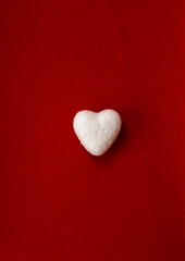 Fototapeta premium white heart on red background. Copy space. advertisement idea.Minimal concept flat lay