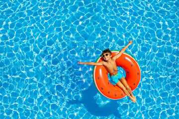 Boy swim on inflatable ring view from above