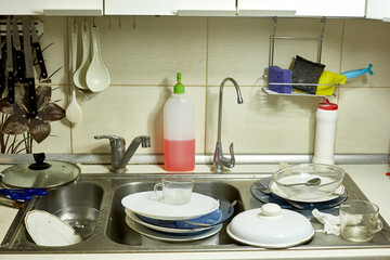 dirty dishes in the sink in the kitchen, lack of water in the water supply and violation of the usual way of life, selective focus