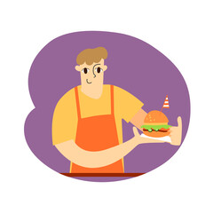 A young guy in an orange apron holds a burger with a striped flag in his hands. Fast food seller. Vector flat illustration