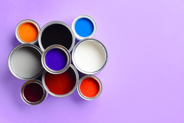 Cans of paints on color background