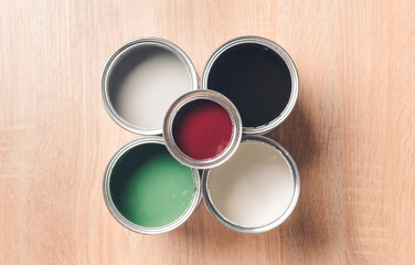 Cans of paints on wooden background